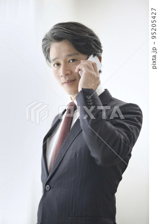 スマートフォンで話す50代男性 95205427