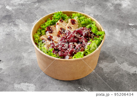 Paper bowl of salad with lettuce, chicken, red beans and mushrooms with teriyaki sauce and sesame Paper bowl of salad with lettuce, chicken, red beans and mushrooms with teriyaki sauce and sesame 95206434