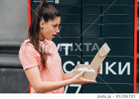 Woman unpack cardboard parcel with online Internet order Woman unpack cardboard parcel with online Internet order 95206705