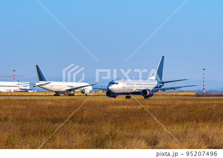 Passenger plane taking off from runway at airport on sunny day. Passenger plane taking off from runway at airport on sunny day. 95207496