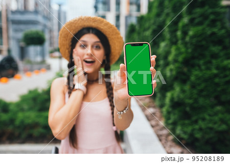 woman showing modern smartphone with green screen for replacement 95208189