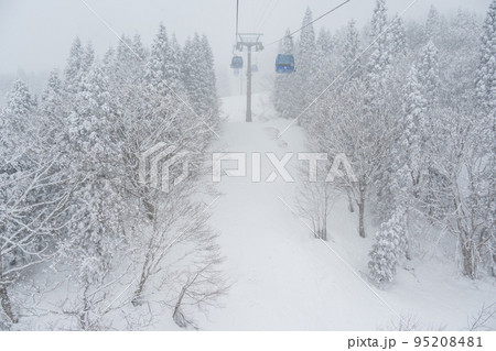 雪が舞う天気が幻想的な雰囲気のスキー場のゴンドラ 95208481