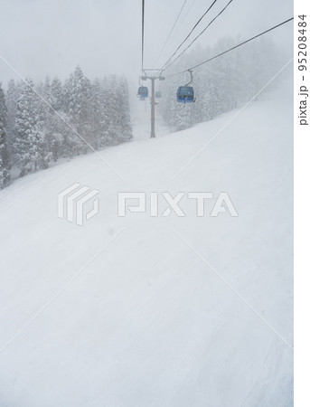雪が舞う天気が幻想的な雰囲気のスキー場のゴンドラ 95208484