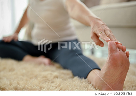 Healthy fit Asian-aged woman stretching leg and arm, practicing yoga. selective focus 95208762