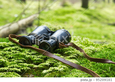 Old vintage binoculars with a leather strap 95209181
