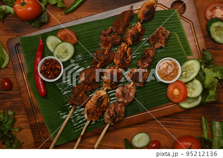 Hot and spicy and delicious street food, grilled meat with Sichuan pepper and vegetable on banana leaf 95212136