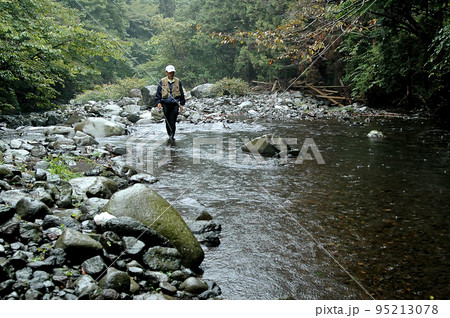 雨の渓流でシーズン最後の渓流釣りをするアングラー 雨の渓流でシーズン最後の渓流釣りをするアングラー 95213078