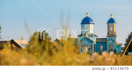 Old wooden orthodox church of the nativity of the Most Holy Theotokos in sunny summer evening. Architectural monument. Glybotskoye, Gomel Region, Belarus 95214070