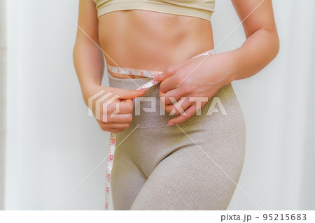 Close Up Of A Slim Woman Holding Measuring Tape Around Her Waist Isolated  Over White Background Stock Photo, Picture and Royalty Free Image. Image  91706923.