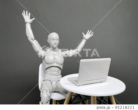 パソコンの画面を見てバンザイをして喜ぶデッサン人形 嬉しい知らせのイメージ の写真素材