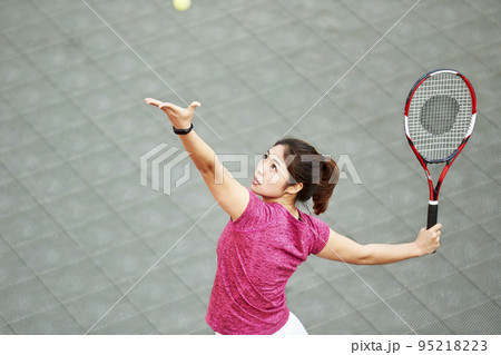 young asian female tennis player serving in match 95218223