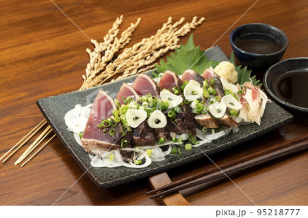 ネギとニンニクをかけた鰹のたたきと日本酒 95218777