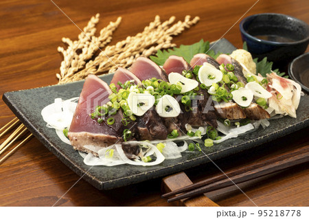 ネギとニンニクをかけた鰹のたたきと日本酒 95218778