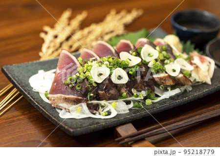ネギとニンニクをかけた鰹のたたきと日本酒 ネギとニンニクをかけた鰹のたたきと日本酒 95218779