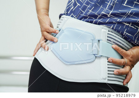 Asian senior wearing elastic support belt can help reduce back pain. 95218979