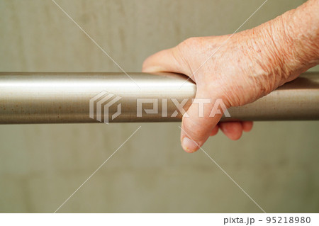 Asian elderly old woman patient use toilet support rail in bathroom, handrail safety grab bar, security in nursing hospital. 95218980
