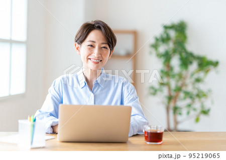 リビングでテレワークをするミドル女性 リビングでテレワークをするミドル女性 95219065