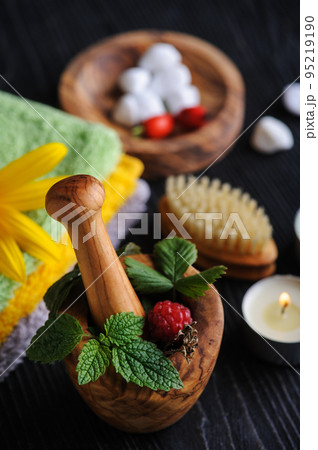 Fresh herbs in wooden mortar and bath bombs Fresh herbs in wooden mortar and bath bombs 95219190