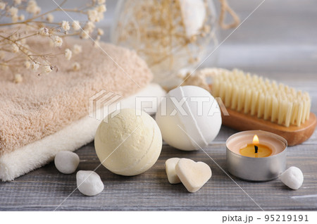 Bath bombs with dry flowers and lit candles Bath bombs with dry flowers and lit candles 95219191