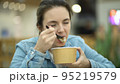 A young girl eats fresh salad from a paper container during her lunch break 95219579