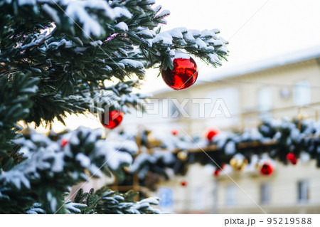 Close up of balls on christmas snowy tree. Christmas decorations. New Year concept. Winter holidays. Close up of balls on christmas snowy tree. Christmas decorations. New Year concept. Winter holidays. 95219588