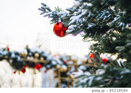 Close up of balls on christmas snowy tree. Christmas decorations. New Year concept. Winter holidays. 95219594