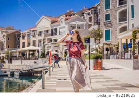 Woman tourist enjoying the views of Architecture and luxury yachts in Lustica Bay, Montenegro. Travel around Montenegro concept. Go Everywhere Woman tourist enjoying the views of Architecture and luxury yachts in Lustica Bay, Montenegro. Travel around Montenegro concept. Go Everywhere 95219625