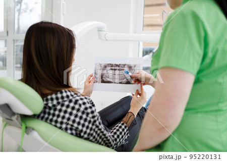 Dentist doctor shows an x-ray of the oral cavity to his patient Dentist doctor shows an x-ray of the oral cavity to his patient 95220131