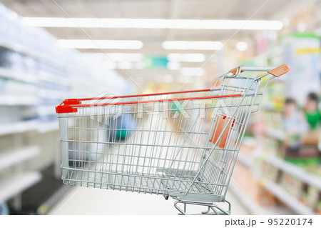 Supermarket aisle with empty shopping cart at grocery store retail business concept Supermarket aisle with empty shopping cart at grocery store retail business concept 95220174