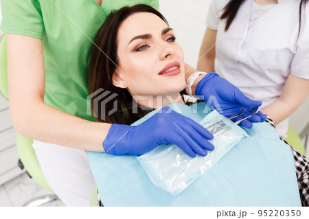 Dentist doctor removes sterile instruments from a bag. Dentist doctor removes sterile instruments from a bag. 95220350