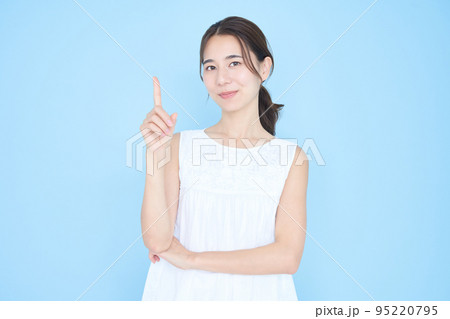 人差し指を立てるポーズをする若い女性 95220795