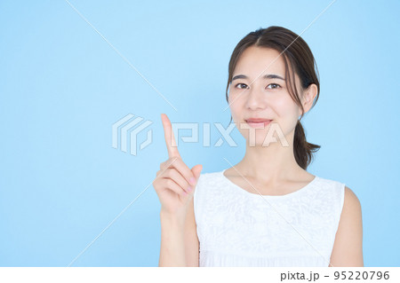 人差し指を立てるポーズをする若い女性 95220796