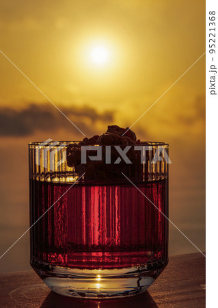 Classic Negroni cocktail alcoholic drink in glass against sunset. 95221368