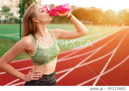 Tired runner drinks water from a bottle 95221662