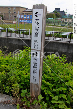 伊丹スポーツセンターを背景に立つ　荒牧バラ公園と 瑞ケ池公園の行先表示 95222807