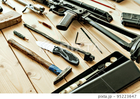 Disassembled rifle with cleaning tools on table of weapons workshop 95223647