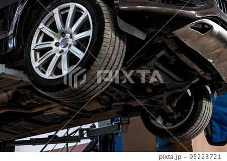 Сar in a car repair service lifted on a jack, view from the bottom 95223721