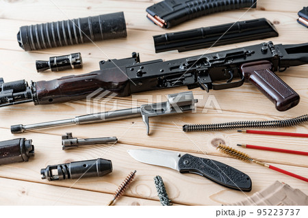 Disassembled rifle with cleaning tools on table of weapons workshop 95223737