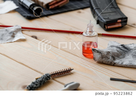 Disassembled rifle with cleaning tools on table of weapons workshop Disassembled rifle with cleaning tools on table of weapons workshop 95223862