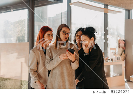 A group of young entrepreneurs on a coffee break discuss the project while using modern editing tablets, a smartphone and a laptop.Business concept 95224074