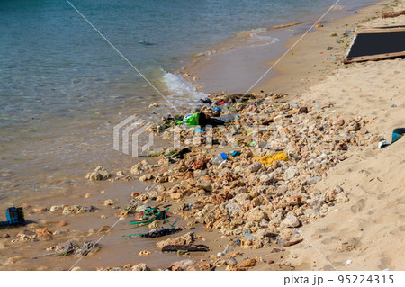 Garbage on a bank of ocean. Pollution of sea, ocean water with waste, plastics garbage. Concept of pollution of ocean, sea and river coastline with plastic trash Garbage on a bank of ocean. Pollution of sea, ocean water with waste, plastics garbage. Concept of pollution of ocean, sea and river coastline with plastic trash 95224315