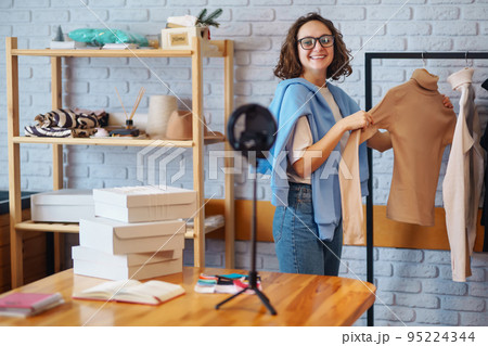 Female warehouse worker, seller, dropshipping small business owner recording new content for vlog. 95224344