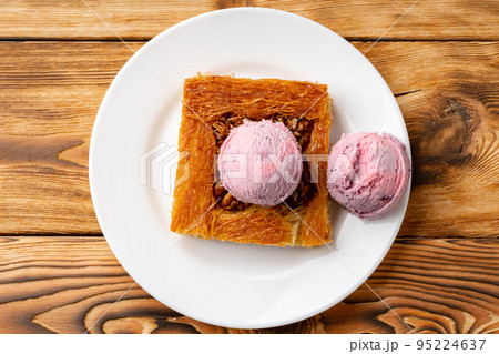 Turkish dessert kunefe served with ice cream on wooden background 95224637