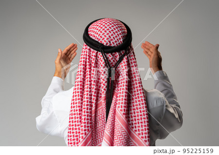 Back view of young Arab man standing on gray background Back view of young Arab man standing on gray background 95225159