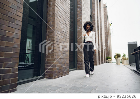 Portrait of attractive young woman walking outside in the city 95225626