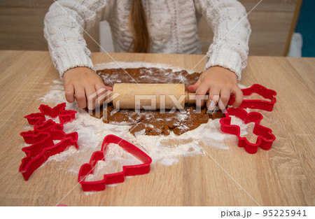Gingerbread dough for Christmas cookies and cookie cutters. Gingerbread dough for Christmas cookies and cookie cutters. 95225941