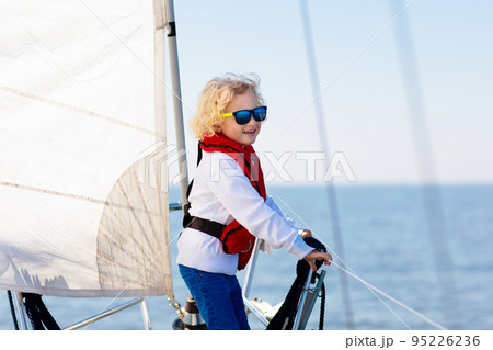 Kids sail on yacht in sea. Child sailing on boat. Kids sail on yacht in sea. Child sailing on boat. 95226236