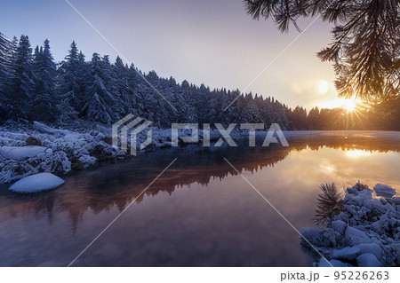 Beautiful Winter Landscape with Pine Forest and Sunset Reflections in the Lake 95226263