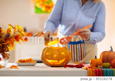 Family carving pumpkin for Halloween 95226278