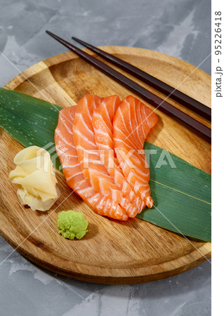 Japanese food style, Top view of salmon slice on bamboo leaves, Salmon sashimi is Japanese traditional, Selective focus, Fish slices top view 95226418